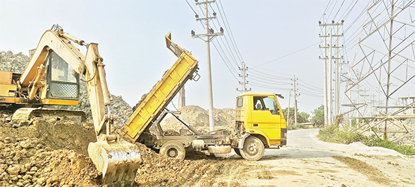 ধামরাইয়ে সড়কের পাশেই ইটভাটার মাটির স্তূপ